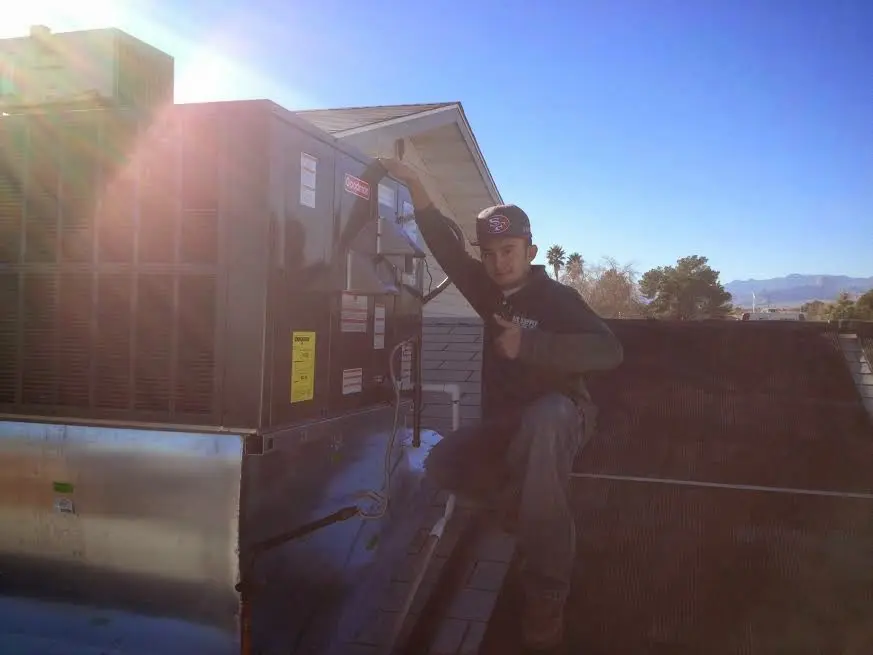 HVAC technician performing Heat Pump Repair on a rooftop unit in Box Elder